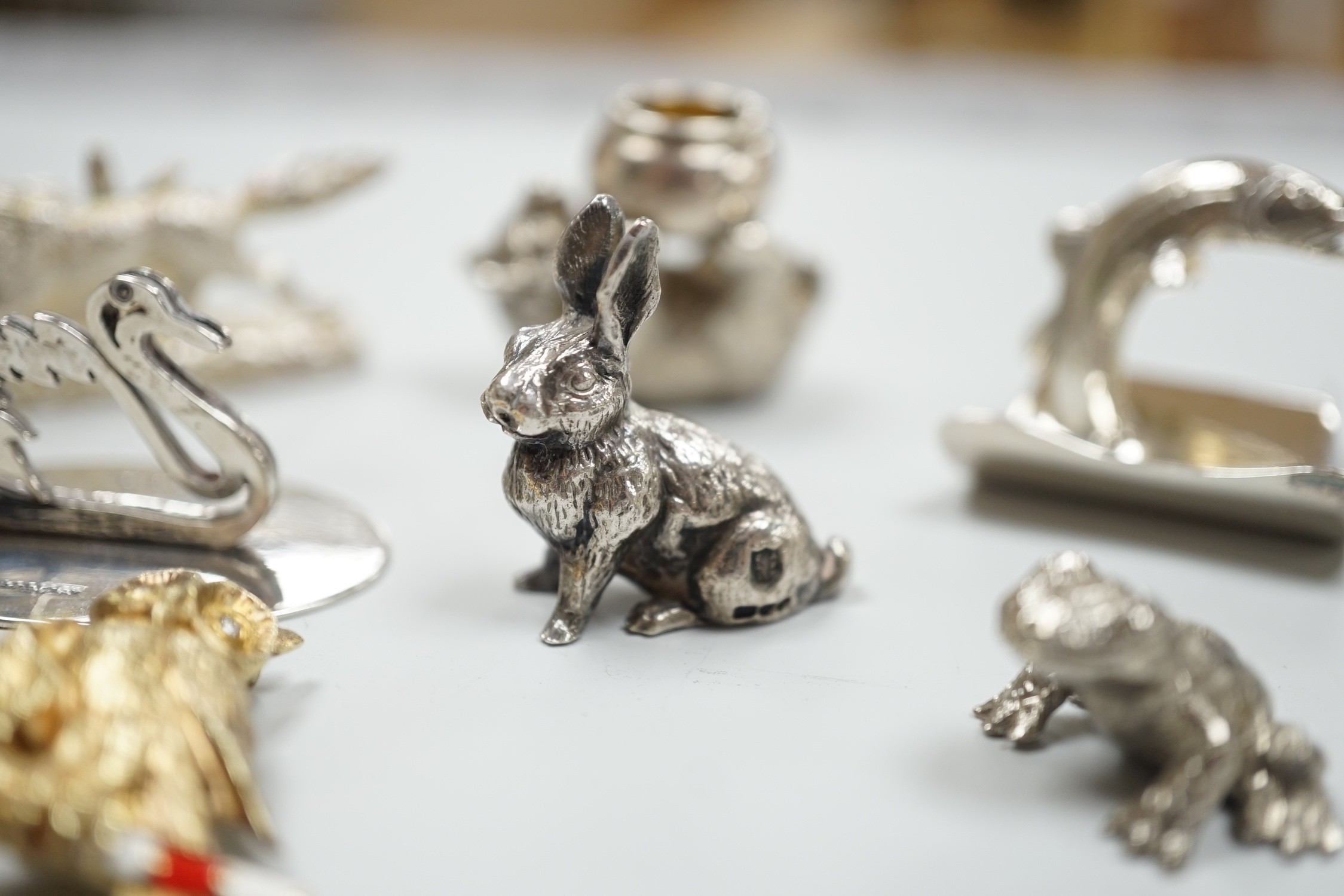 Eight assorted modern silver miniature animal or bird figures including menu holders, including rabbit by Tessiers Ltd, height 27mm, an earlier silver swan menu holder and a silver gilt owl brooch.